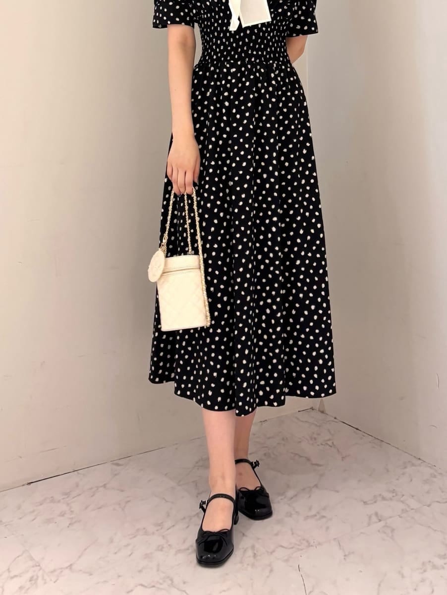 ブラック系のワンピース、ホワイト系のショルダーバッグ、ブラック系のパンプスを着用したレディースの夏コーディネートの6枚目の写真