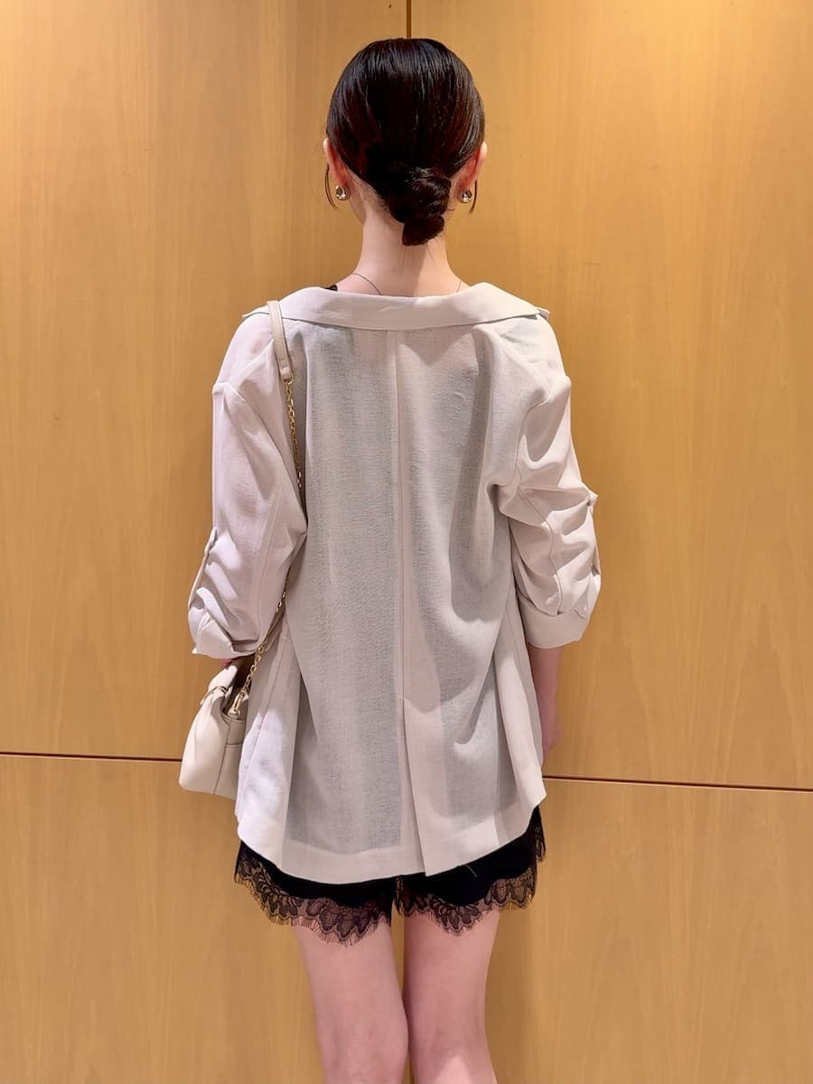 ホワイト系のテーラードジャケット、ブラック系のキャミソール、ブラック系のその他パンツを着用したレディースの夏コーディネートの3枚目の写真