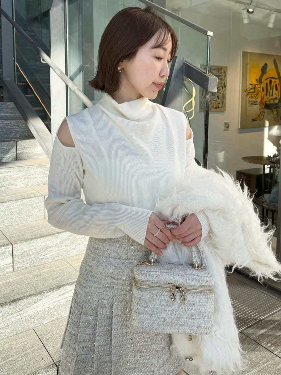 ホワイト系のスカート、ホワイト系のカーディガン/ボレロ、ホワイト系のハンドバッグを着用したレディースの冬コーディネートの7枚目の写真