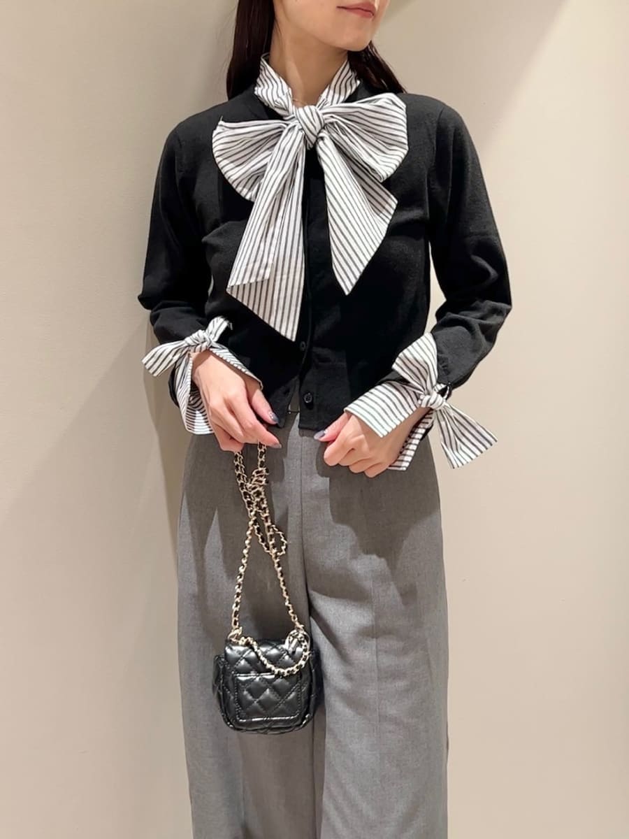 ブラック系のニット/セーター、グレー系のスラックス、ブラック系のショルダーバッグを着用したレディースの秋コーディネートの4枚目の写真