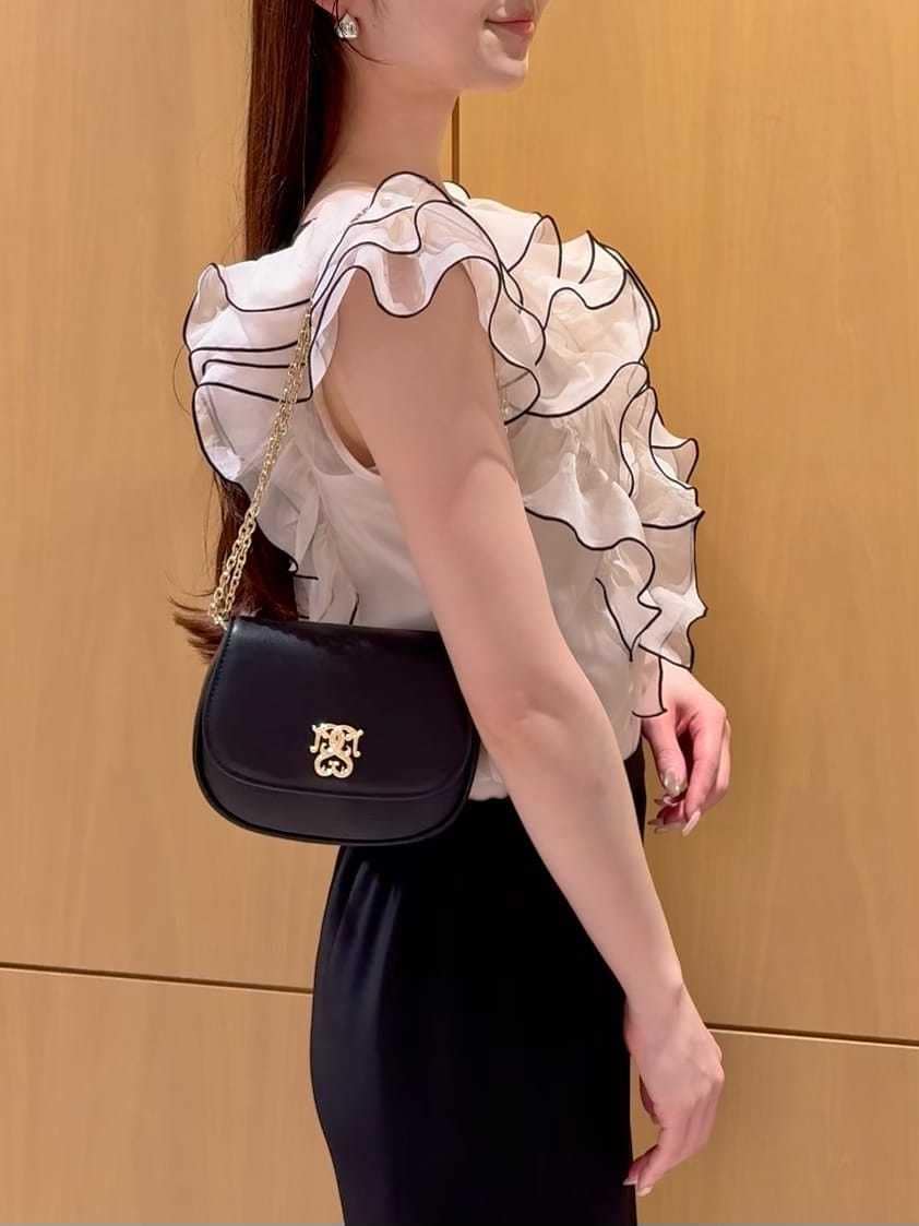 ブラック系のスカート、ベージュ系のシャツ/ブラウス、ブラック系のパンプスを着用したレディースの春コーディネートの6枚目の写真