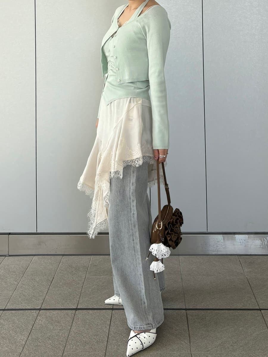 グレー系のデニムパンツ、ホワイト系のキャミソール、グリーン系のカーディガン/ボレロを着用したレディースの春コーディネートの3枚目の写真