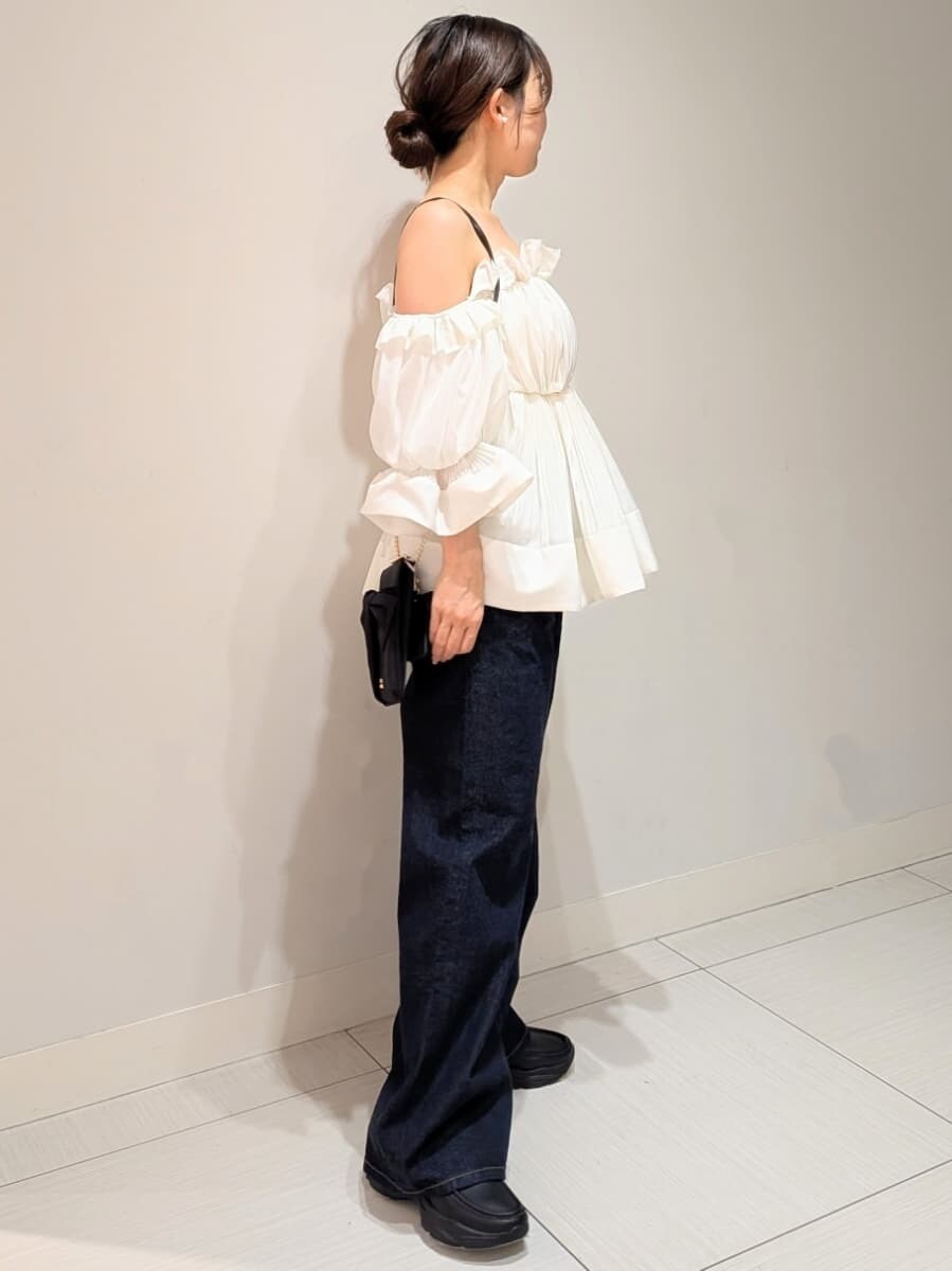 ブルー系のデニムパンツ、ホワイト系のその他トップス、ブラック系のショルダーバッグを着用したレディースの春コーディネートの2枚目の写真