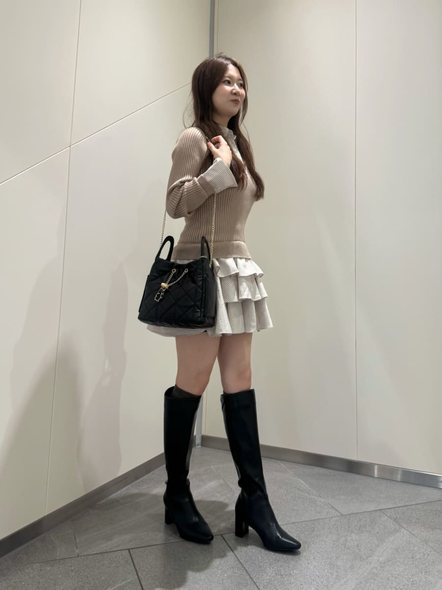 ベージュ系のワンピース、ブラック系のブーツ、ブラック系のショルダーバッグを着用したレディースの秋コーディネートの2枚目の写真