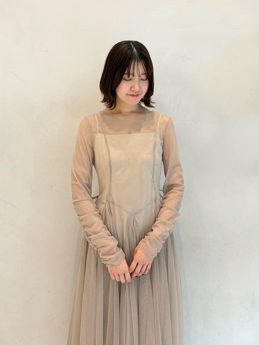 グレー系のドレス、ブラック系のパンプス、ホワイト系のハンドバッグを着用したレディースの冬コーディネートの5枚目の写真