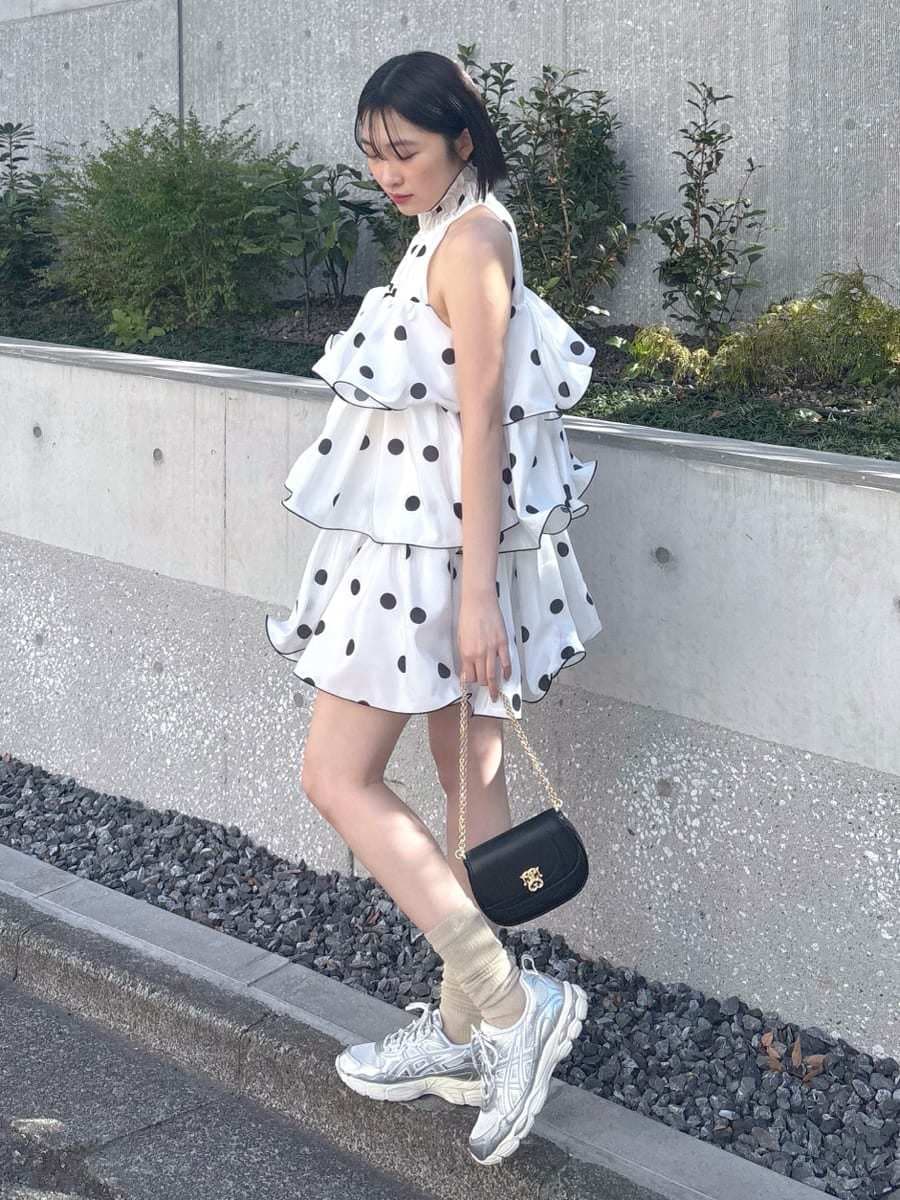 ホワイト系のワンピース、ブラック系のショルダーバッグ、シルバー系のスニーカーを着用したレディースの冬コーディネートの3枚目の写真