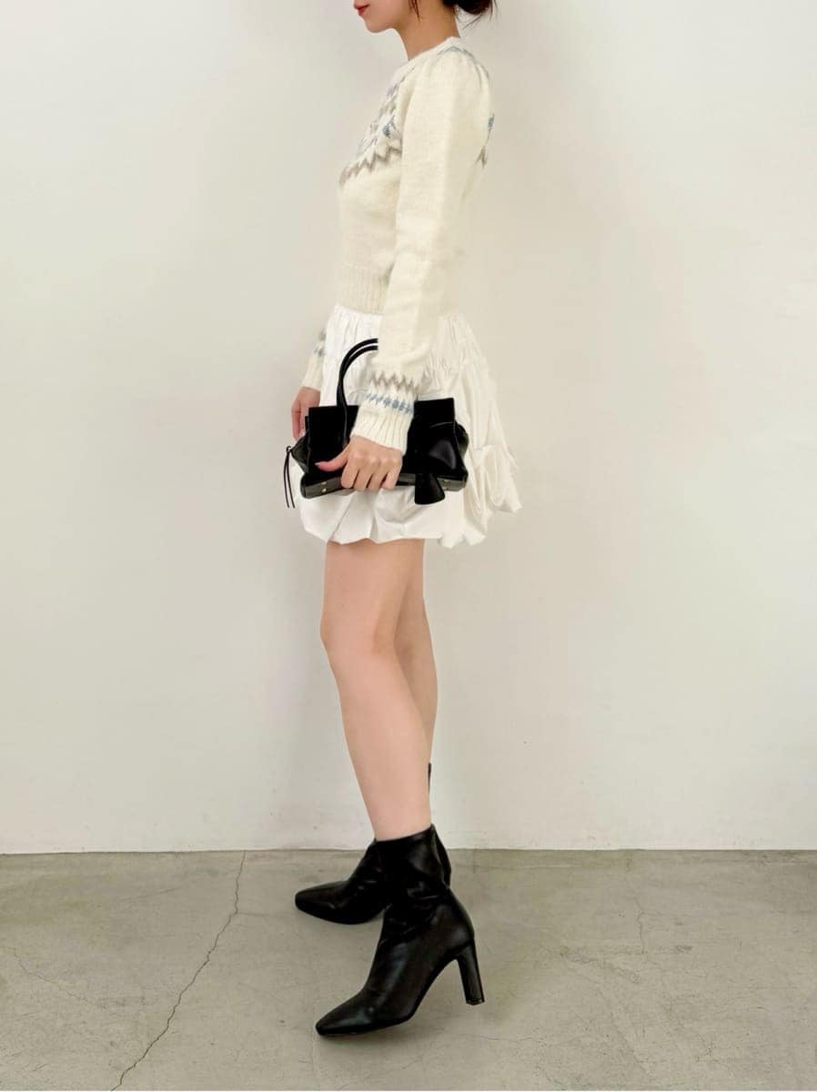 ブラック系のブーツ、ホワイト系のその他パンツ、ホワイト系のニット/セーターを着用したレディースの冬コーディネートの3枚目の写真