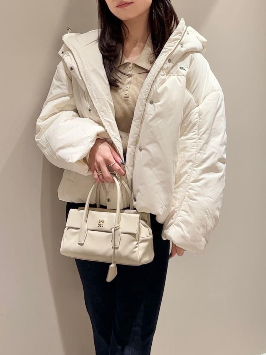 ホワイト系のダウンジャケット/コート、イエロー系のニット/セーター、ブルー系のその他パンツを着用したレディースの秋コーディネートの4枚目の写真