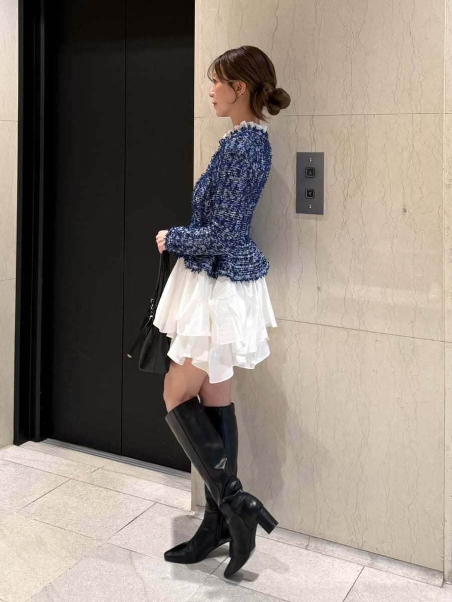ブルー系のワンピース、ブラック系のブーツ、ブラック系のボストンバッグを着用したレディースの秋コーディネートの2枚目の写真