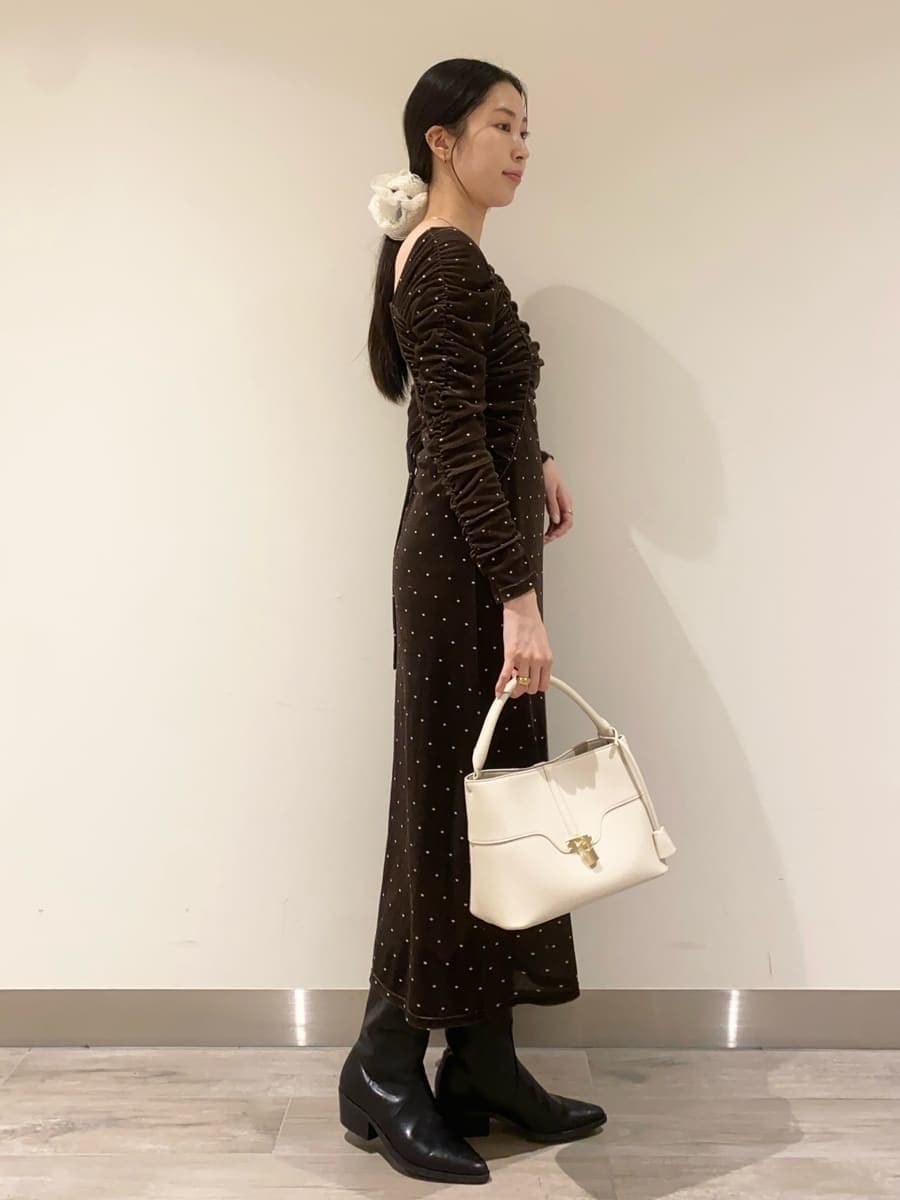 ブラック系のパンプス、その他のワンピース、ホワイト系のハンドバッグを着用したレディースの冬コーディネートの2枚目の写真