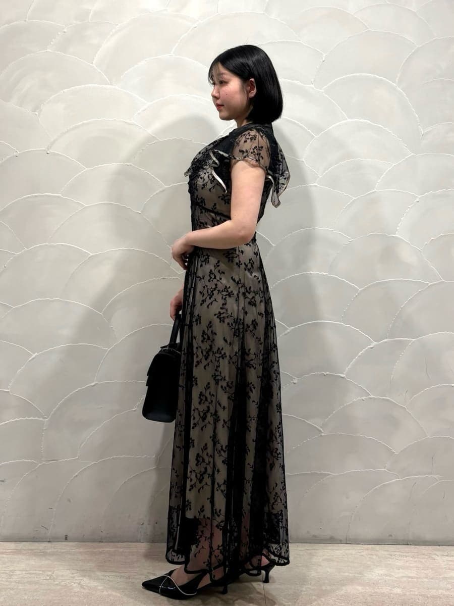 ブラック系のパンプス、ブラック系のハンドバッグ、ブラック系のドレスを着用したレディースの春コーディネートの2枚目の写真