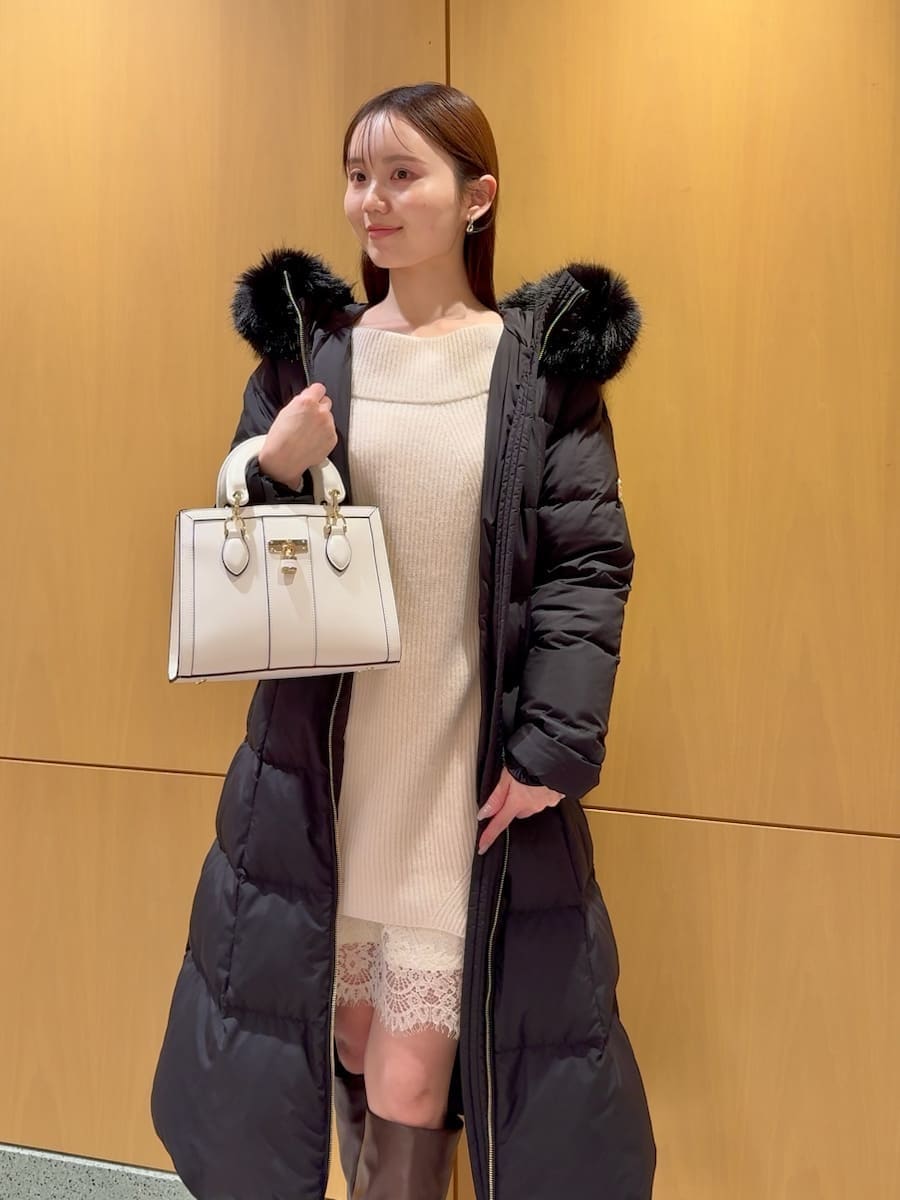ホワイト系のワンピース、ブラック系のダウンジャケット/コート、ホワイト系のハンドバッグを着用したレディースの冬コーディネートの6枚目の写真
