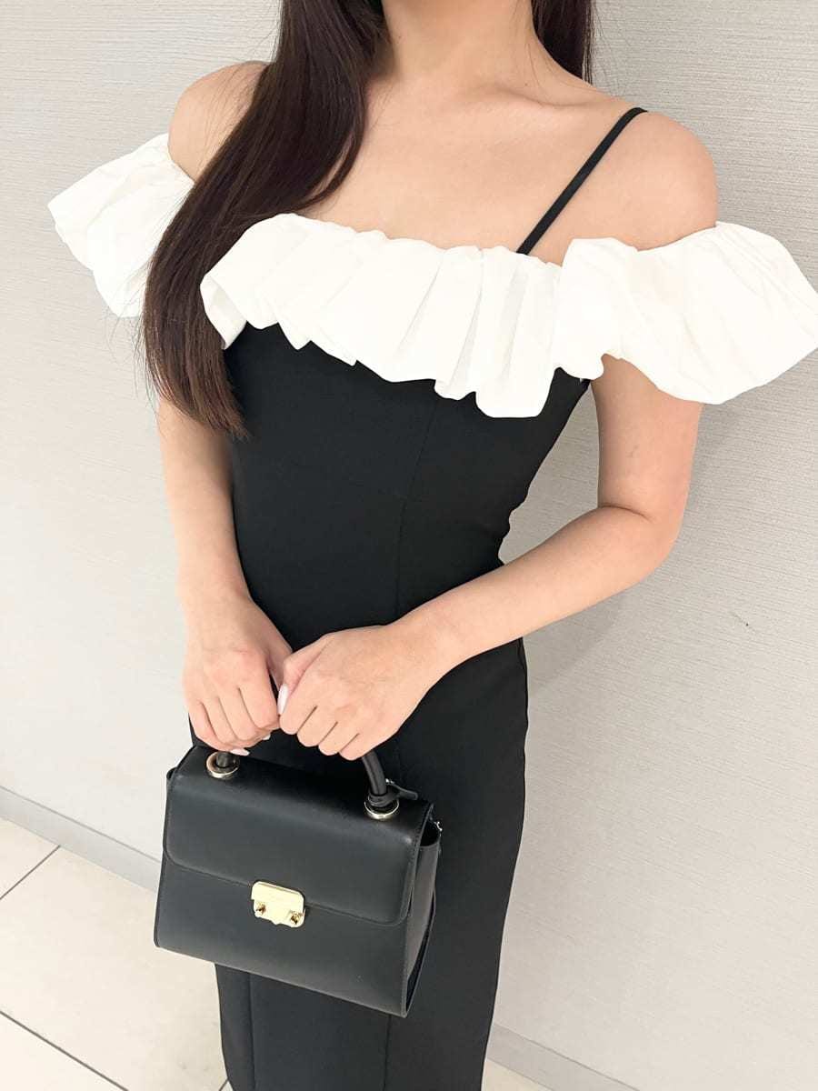 ブラック系のワンピース、ホワイト系のサンダル、ブラック系のショルダーバッグを着用したレディースの夏コーディネートの2枚目の写真