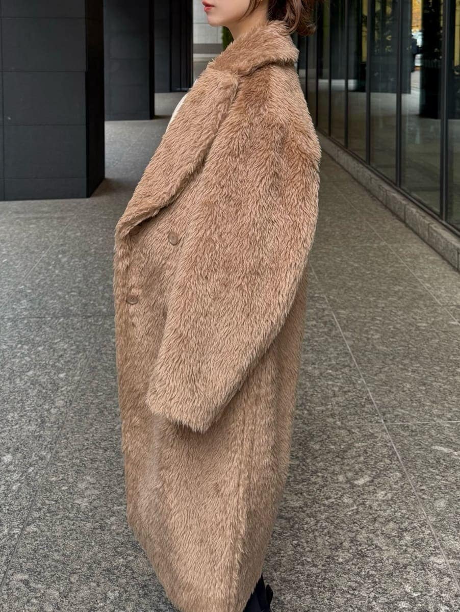 ホワイト系のその他パンツ、ホワイト系のニット/セーター、ホワイト系のハンドバッグを着用したレディースの冬コーディネートの2枚目の写真