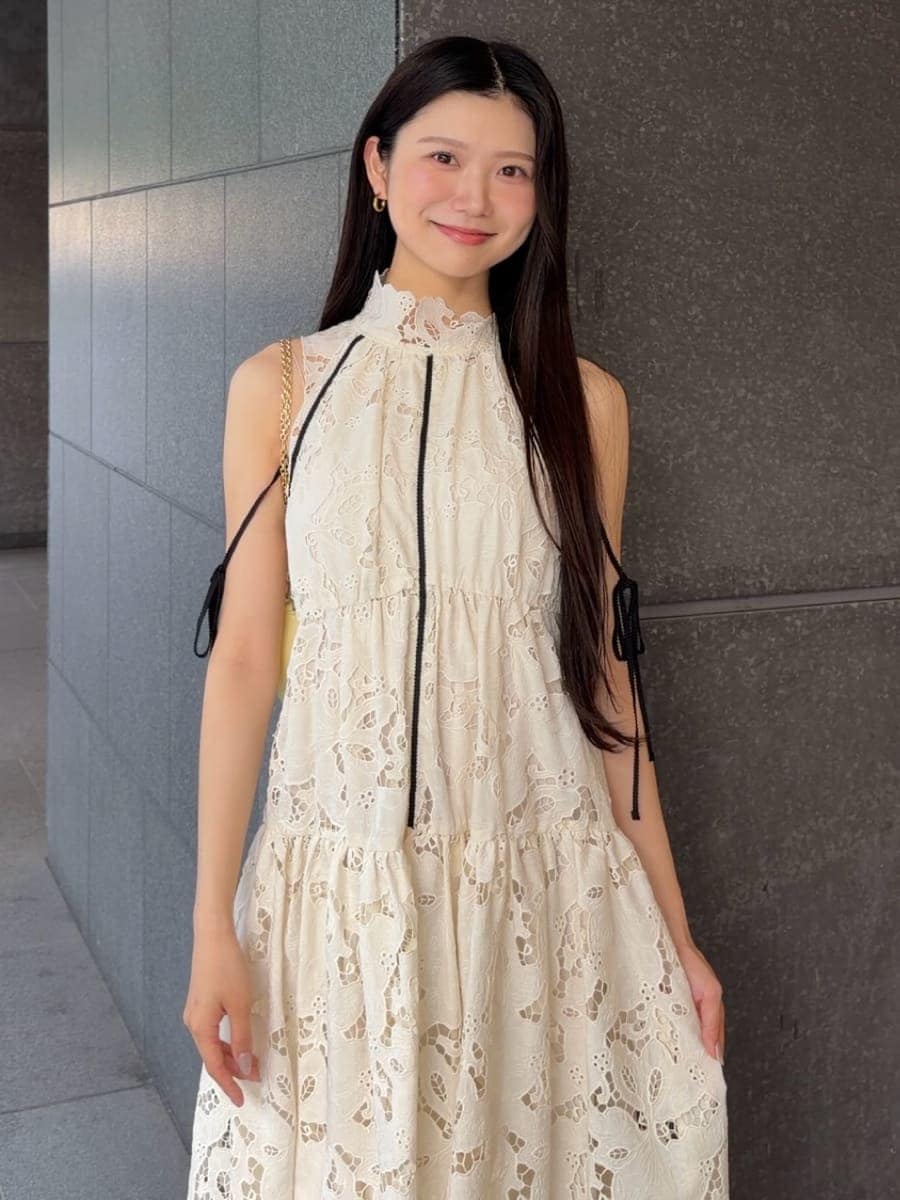 イエロー系のショルダーバッグ、ホワイト系のワンピース、ブラウン系のサンダルを着用したレディースの夏コーディネートの5枚目の写真