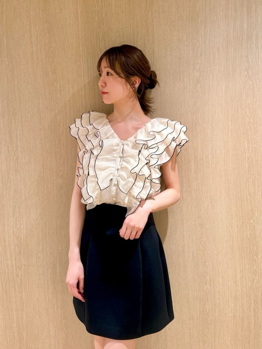 ブルー系のスカート、ベージュ系のシャツ/ブラウスを着用したレディースの春コーディネートの3枚目の写真