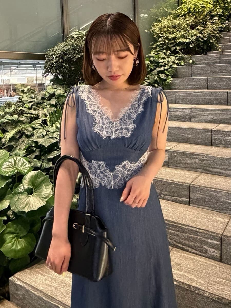 ホワイト系のサンダル、ブルー系のワンピース、ブラック系のボストンバッグを着用したレディースの夏コーディネートの6枚目の写真