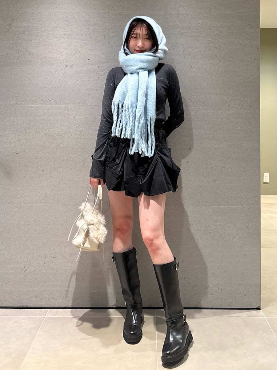 ブラック系のブーツ、ブルー系のチェスターコート、ブラック系のその他パンツを着用したレディースの冬コーディネートの2枚目の写真