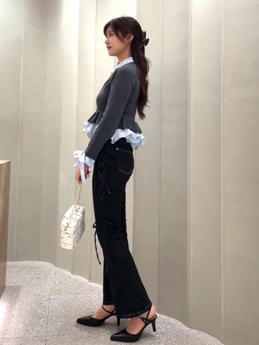 ブラック系のデニムパンツ、グレー系のカーディガン/ボレロ、ブラック系のパンプスを着用したレディースの秋コーディネートの3枚目の写真