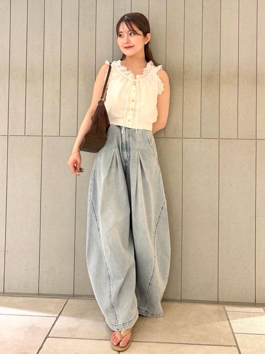 ブルー系のデニムパンツ、ホワイト系のシャツ/ブラウス、ブラウン系のショルダーバッグを着用したレディースの夏コーディネートの2枚目の写真