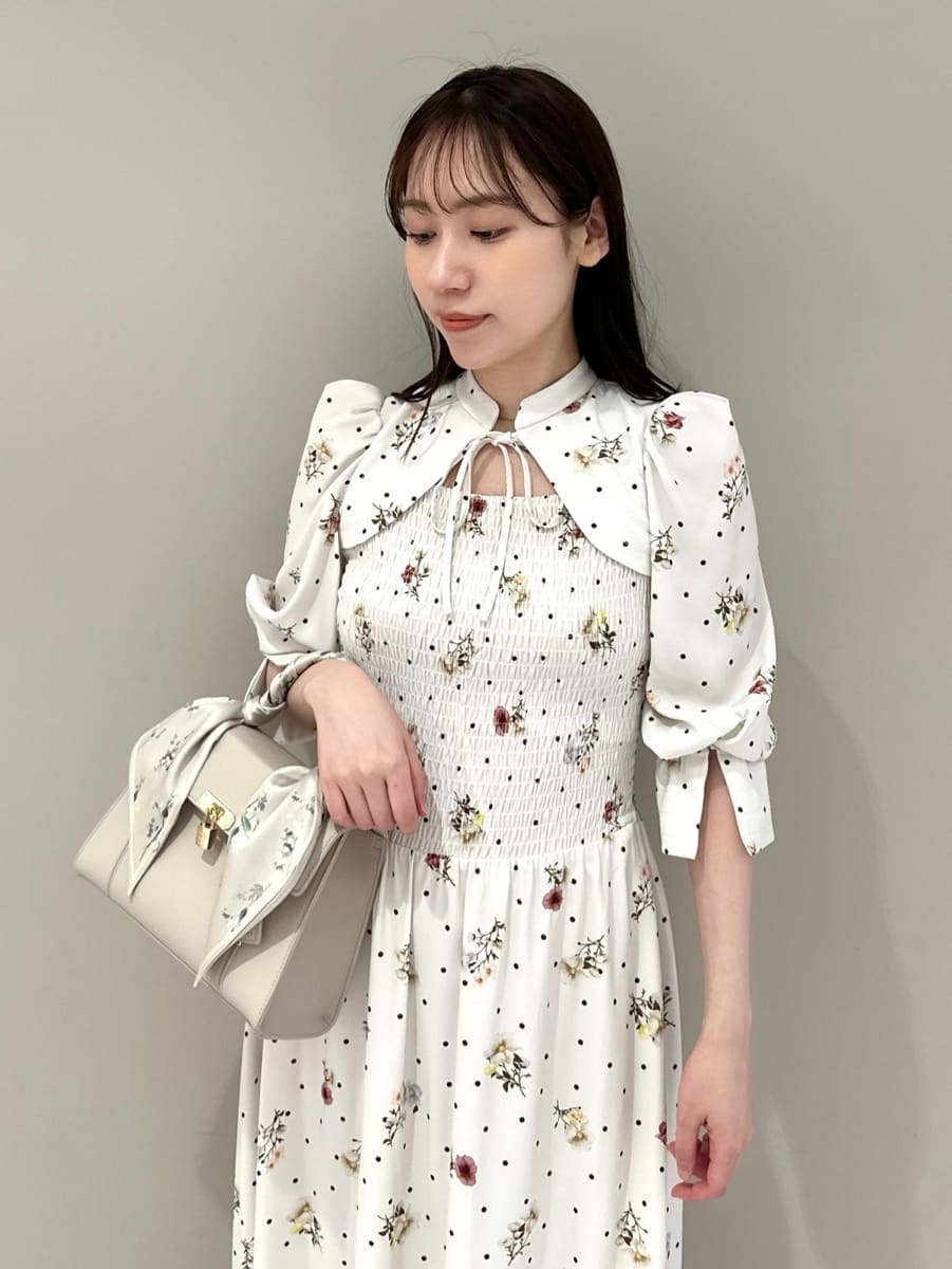 ブラウン系のパンプス、ベージュ系のハンドバッグ、その他のワンピースを着用したレディースの春コーディネートの2枚目の写真