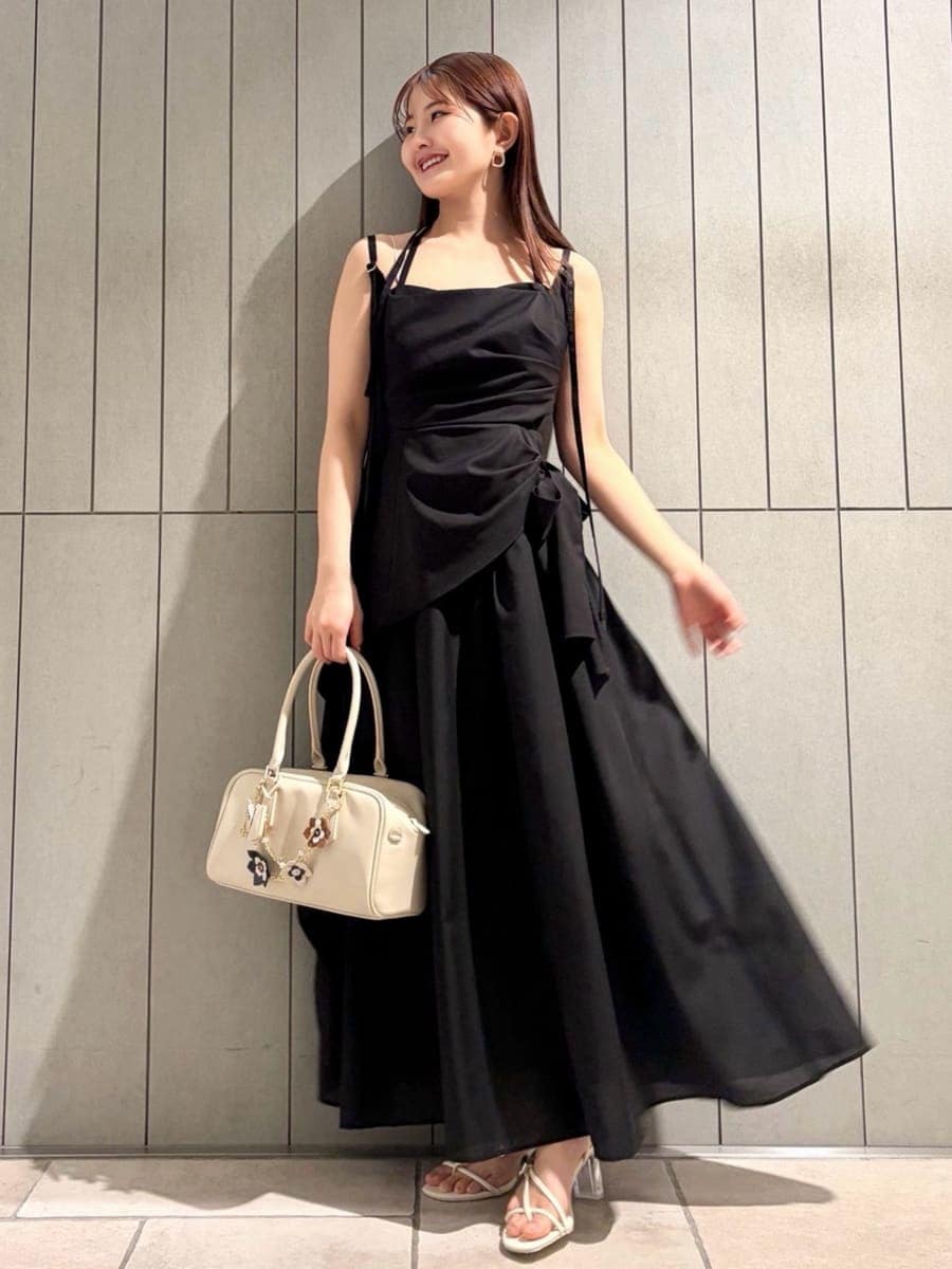 ブラック系のワンピース、グリーン系のTシャツ/カットソー、ホワイト系のボストンバッグを着用したレディースの春コーディネートの4枚目の写真
