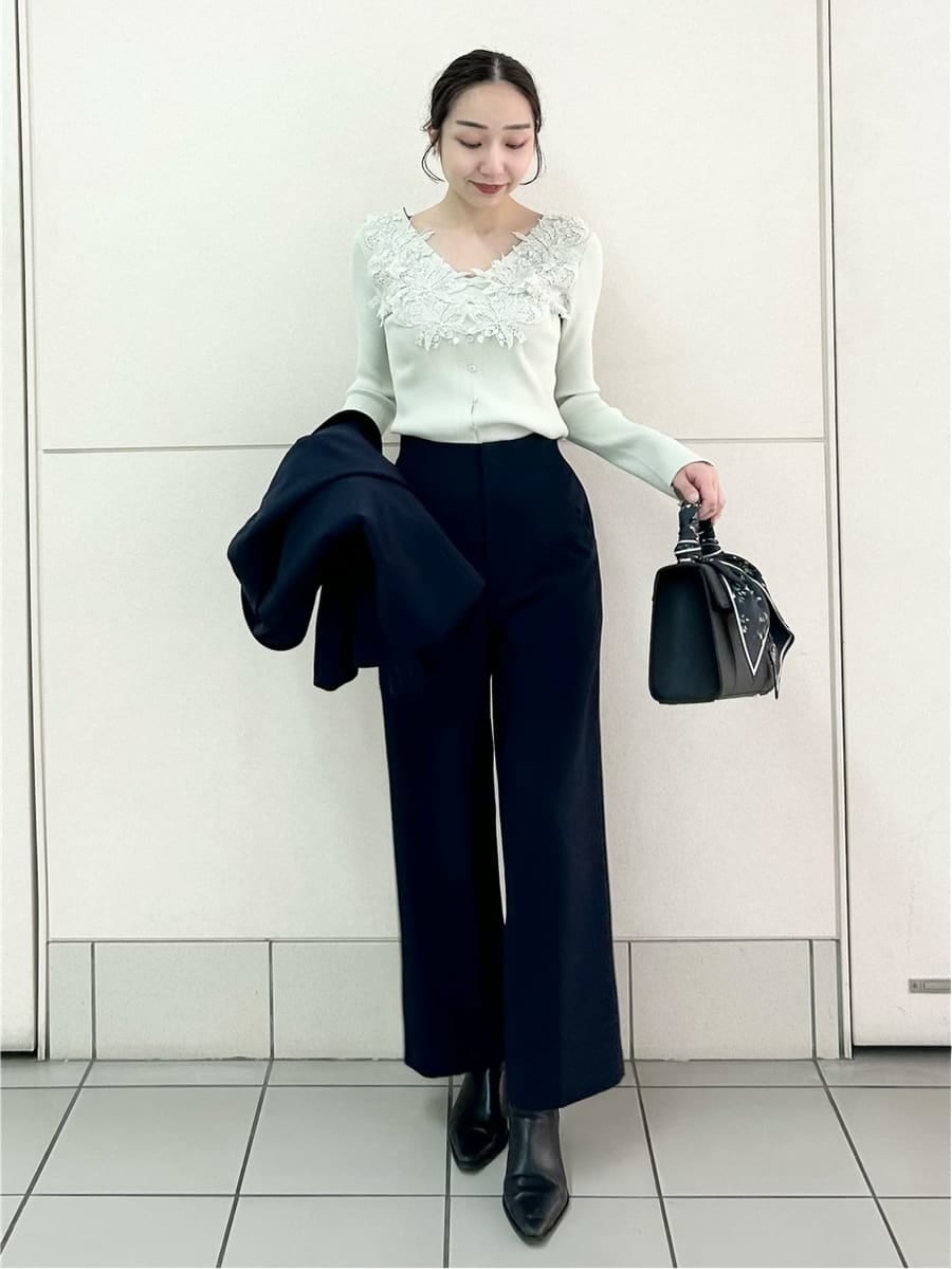 ブルー系のテーラードジャケット、ブルー系のスラックス、ブラック系のハンドバッグを着用したレディースの冬コーディネートの3枚目の写真