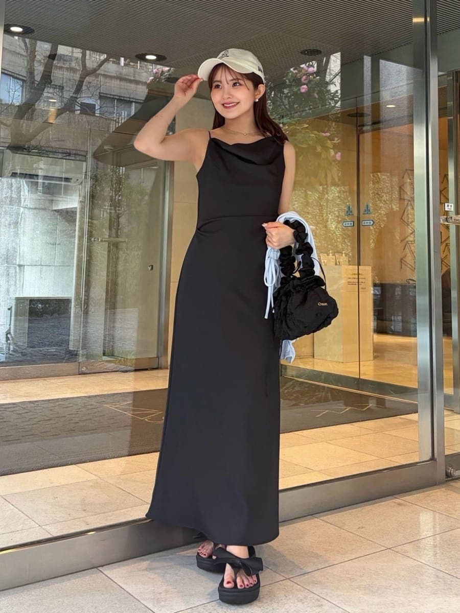 ブラック系のワンピース、ブルー系のカーディガン/ボレロ、ホワイト系のキャップを着用したレディースの春コーディネートの5枚目の写真