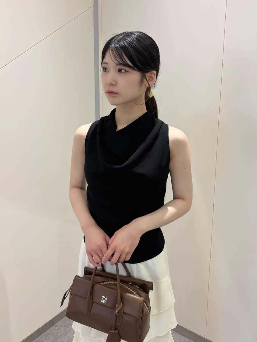 イエロー系のボストンバッグ、ブラウン系のサンダル、ホワイト系のスカートを着用したレディースの夏コーディネートの3枚目の写真