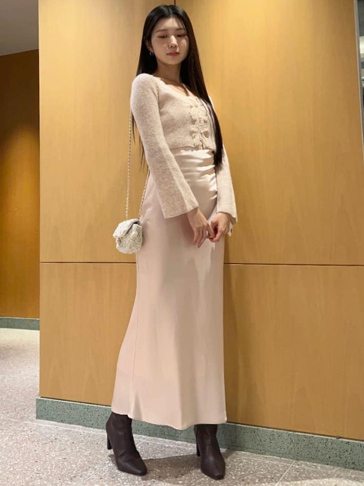 レッド系のブーツ、ホワイト系のショルダーバッグ、ピンク系のワンピースを着用したレディースの秋コーディネートの2枚目の写真