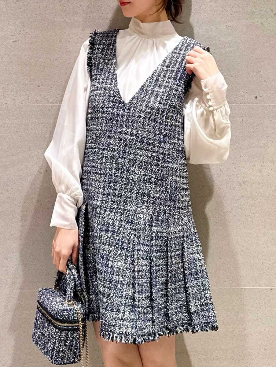 ブルー系のワンピース、ブルー系のハンドバッグ、その他のイヤリングを着用したレディースの冬コーディネートの3枚目の写真