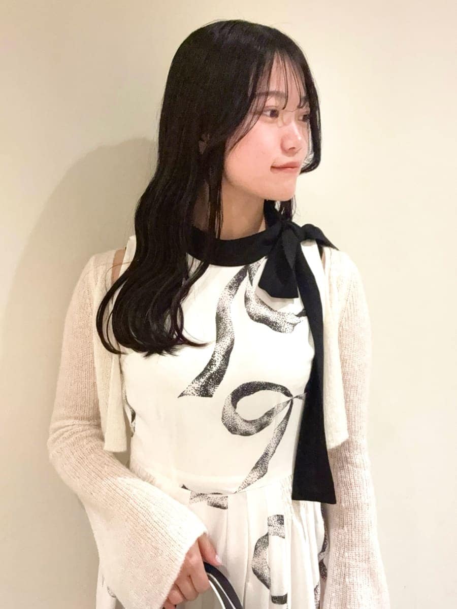 ホワイト系のワンピース、ブラック系のパンプス、ブラック系のハンドバッグを着用したレディースの冬コーディネートの5枚目の写真