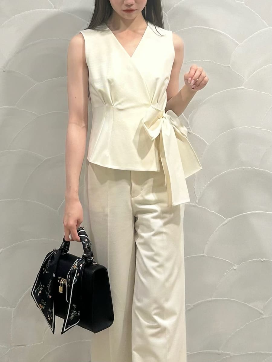 ホワイト系のテーラードジャケット、ホワイト系のスラックス、ブラウン系のパンプスを着用したレディースの冬コーディネートの6枚目の写真