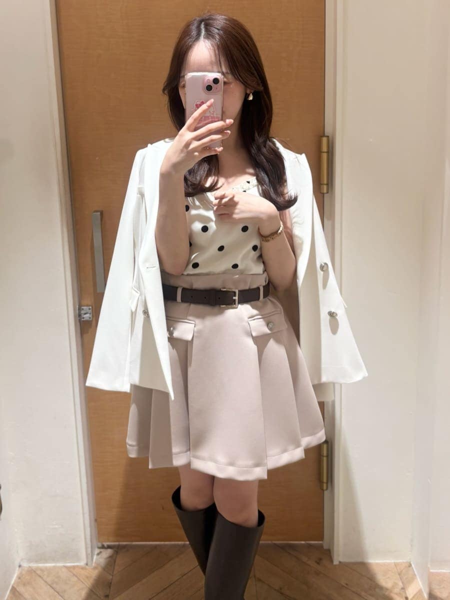 ブラウン系のブーツ、ホワイト系のテーラードジャケット、ベージュ系のスカートを着用したレディースの冬コーディネートの8枚目の写真