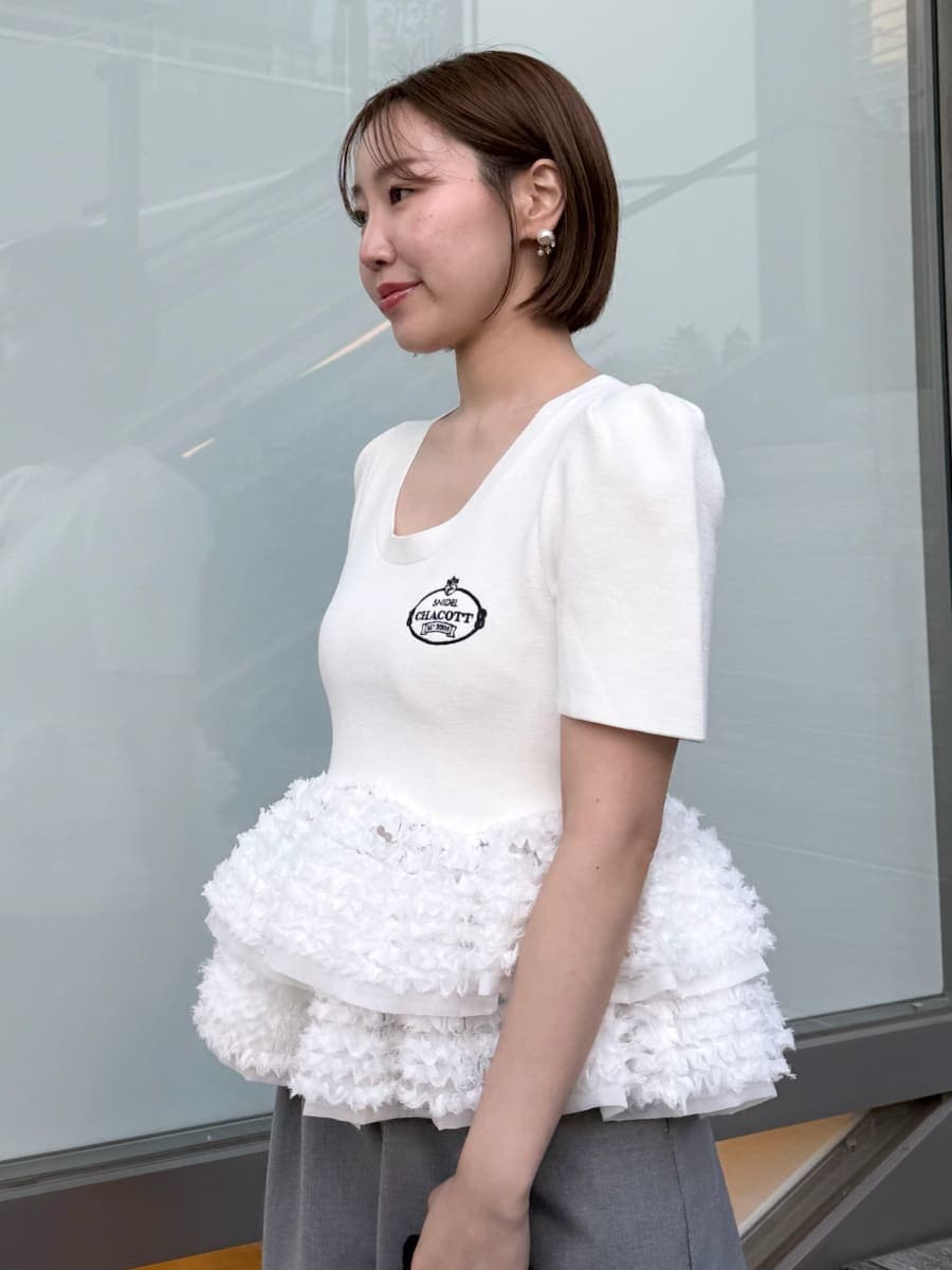 ホワイト系のニット/セーター、グレー系のその他パンツを着用したレディースの春コーディネートの6枚目の写真