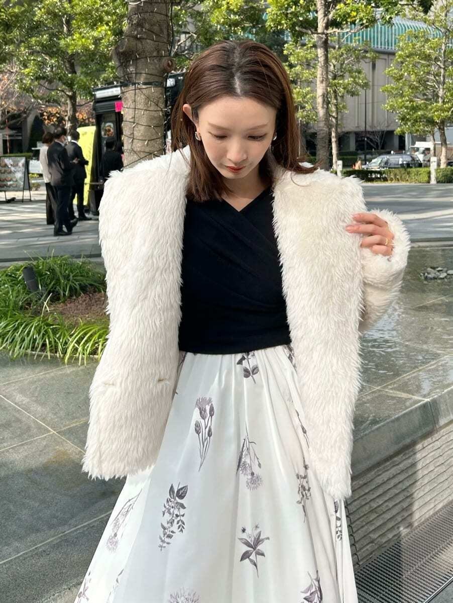 グレー系のブーツ、ホワイト系のムートンコートを着用したレディースの冬コーディネートの5枚目の写真