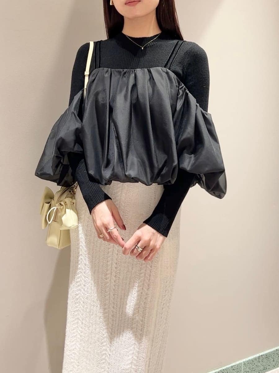 ホワイト系のスカート、ブラック系のニット/セーター、イエロー系のショルダーバッグを着用したレディースの秋コーディネートの3枚目の写真