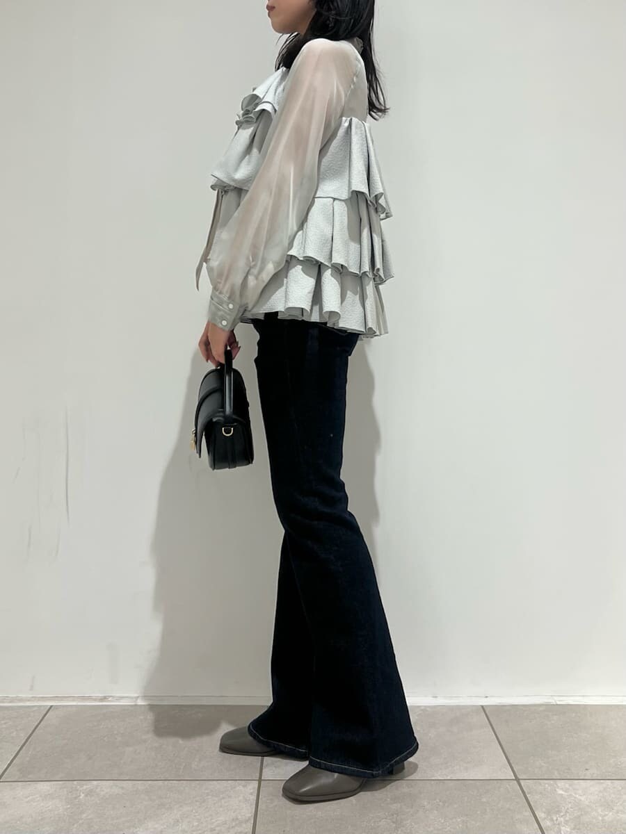 ブラック系のハンドバッグ、ブルー系のその他パンツ、グリーン系のドレスを着用したレディースの冬コーディネートの2枚目の写真