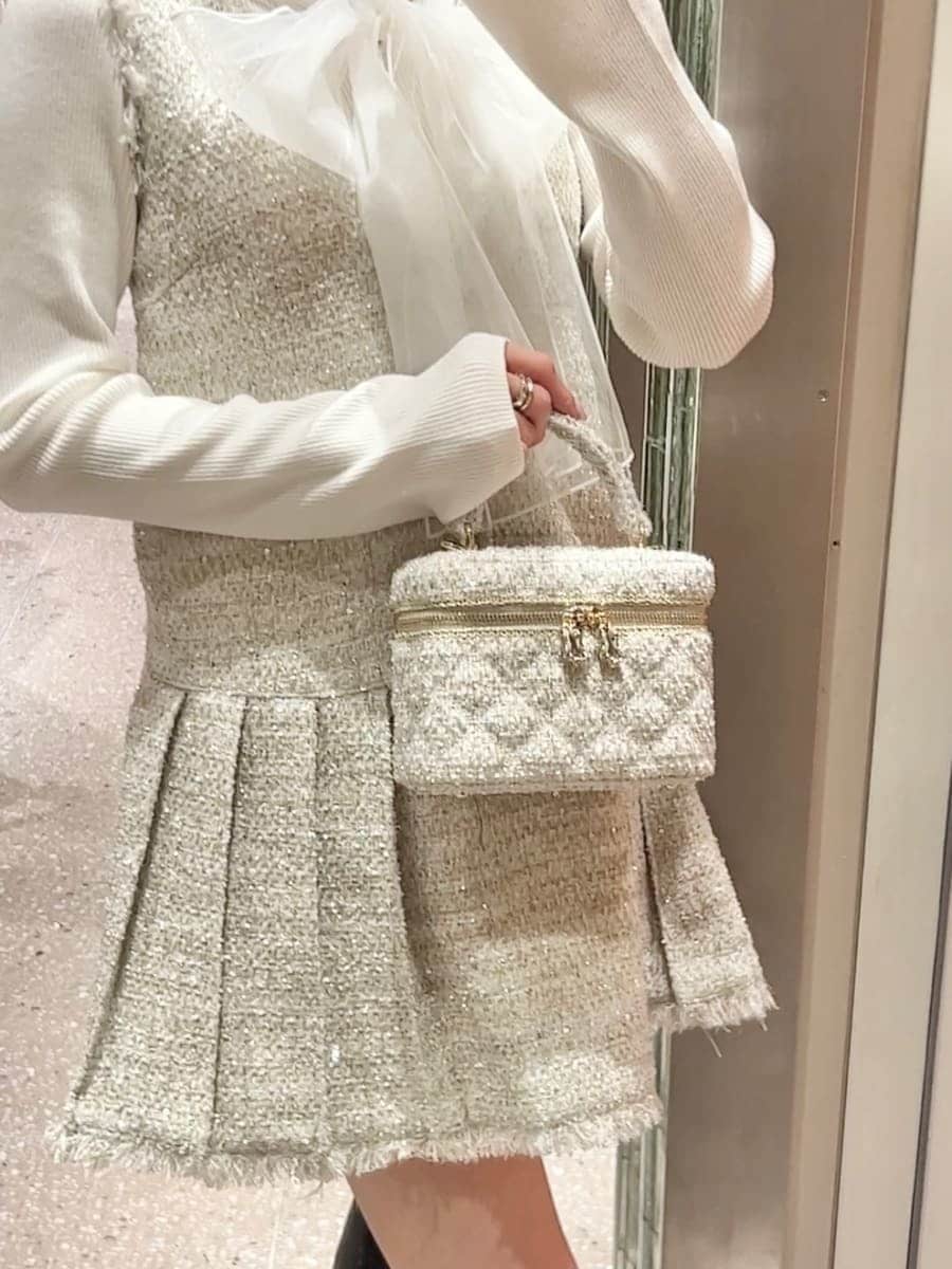 ホワイト系のニット/セーター、ブラック系のブーツ、ブラック系のダウンジャケット/コートを着用したレディースの冬コーディネートの8枚目の写真