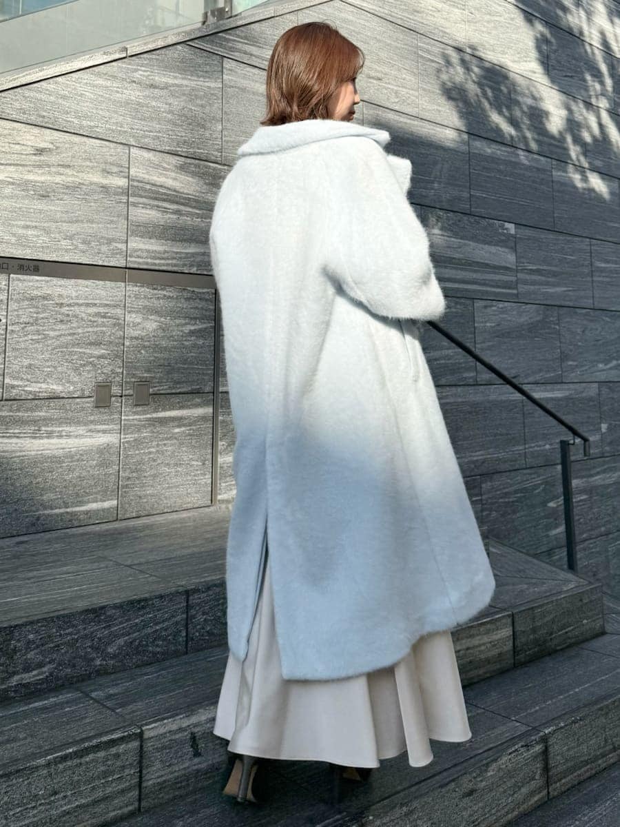 ブルー系のチェスターコート、ホワイト系のワンピースを着用したレディースの冬コーディネートの7枚目の写真