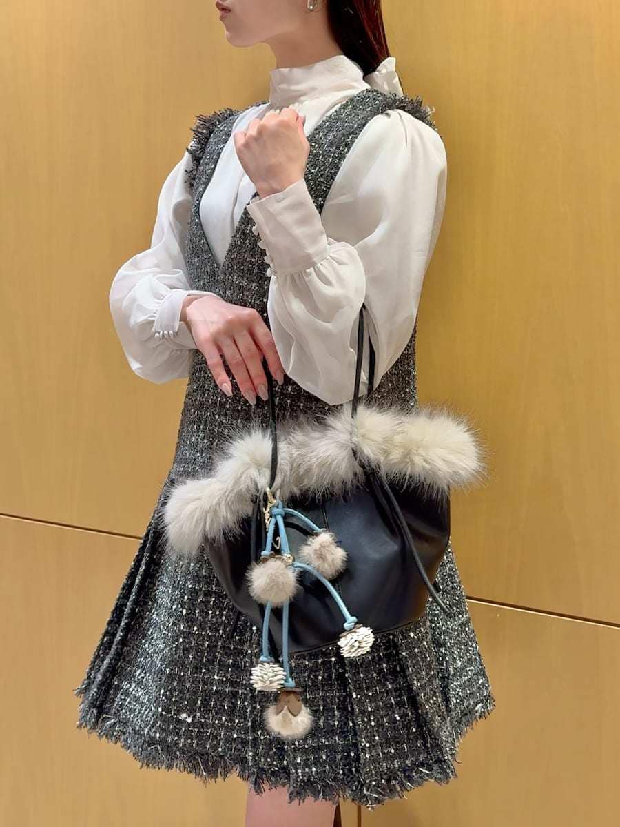 ブラック系のブーツ、グレー系のワンピース、ブラック系のハンドバッグを着用したレディースの冬コーディネートの6枚目の写真