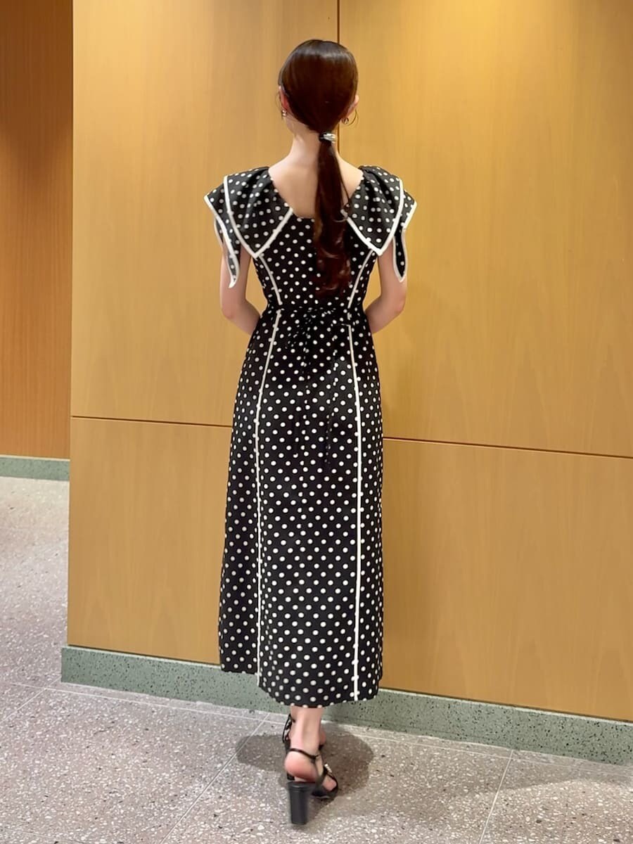 ブラック系のワンピース、ホワイト系のショルダーバッグを着用したレディースの春コーディネートの3枚目の写真