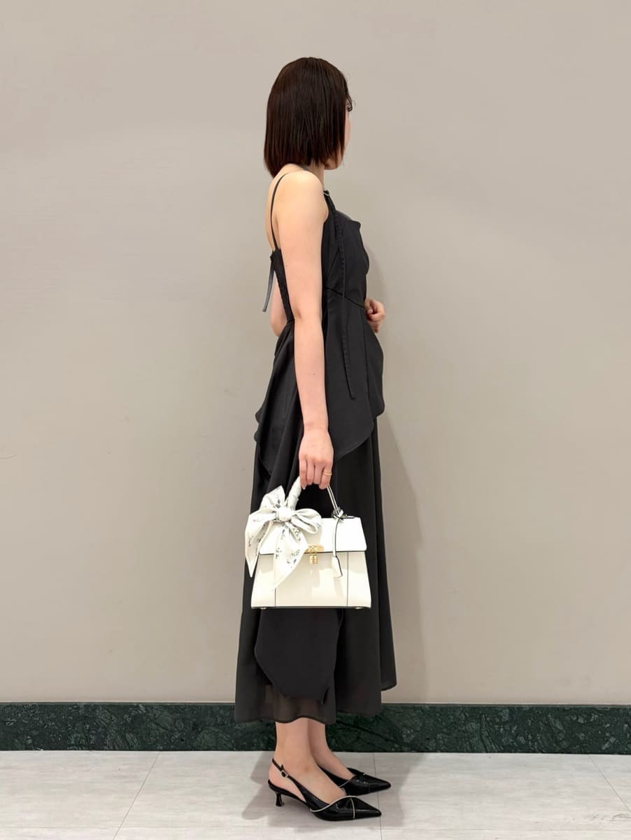 グレー系のワンピース、ホワイト系のカーディガン/ボレロ、ブラック系のパンプスを着用したレディースの春コーディネートの6枚目の写真