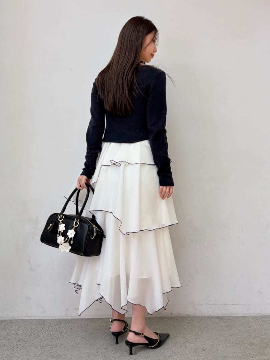 ベージュ系のトレンチコート、ブルー系のワンピース、ブラック系のパンプスを着用したレディースの冬コーディネートの8枚目の写真