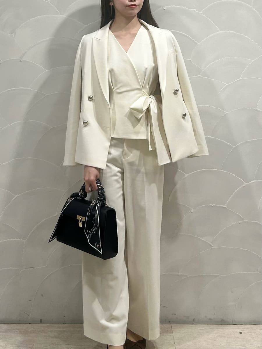 ホワイト系のテーラードジャケット、ホワイト系のスラックス、ブラウン系のパンプスを着用したレディースの冬コーディネートの3枚目の写真