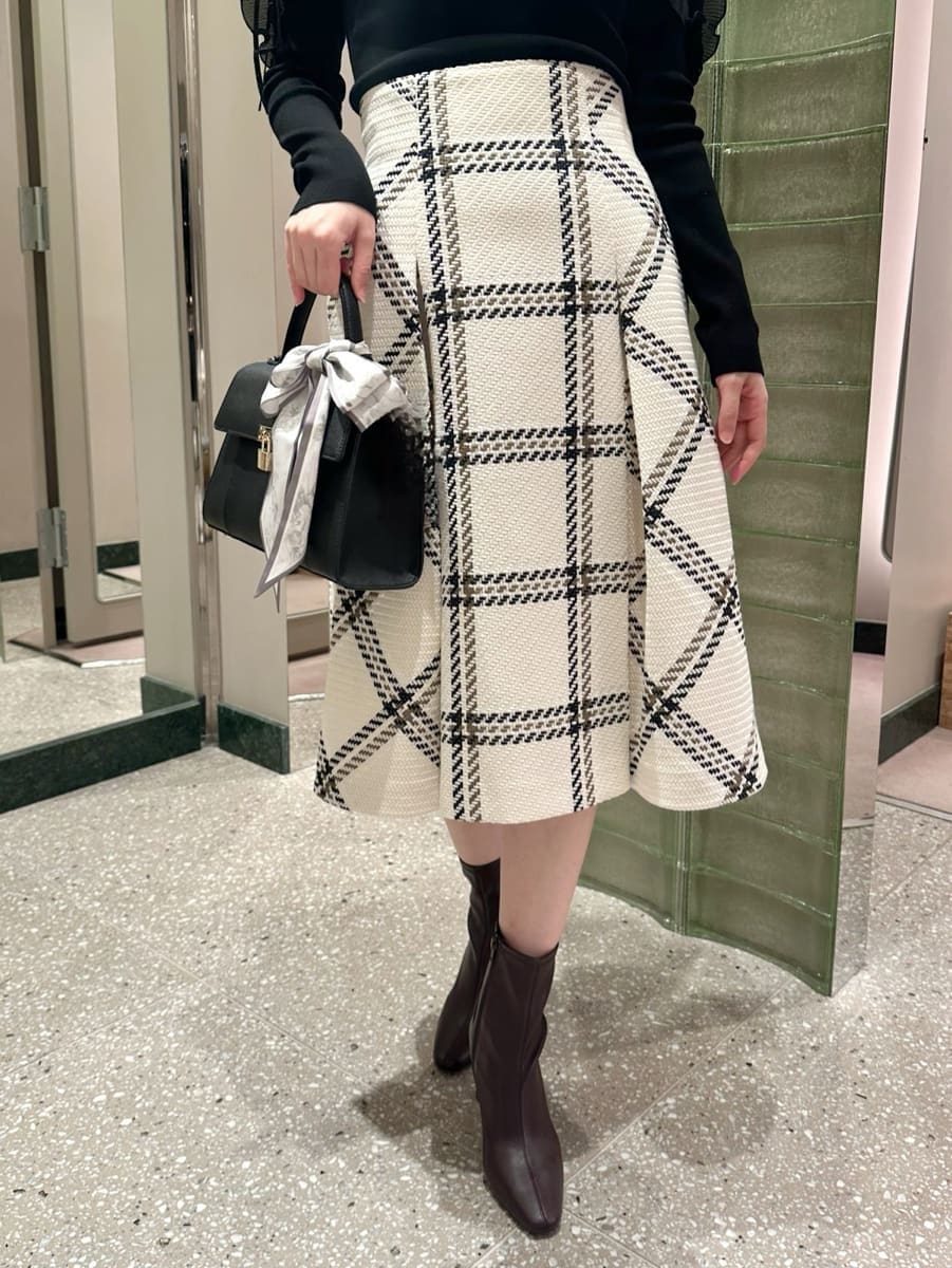 ブラック系のニット/セーター、ホワイト系のスカート、レッド系のブーツを着用したレディースの秋コーディネートの3枚目の写真