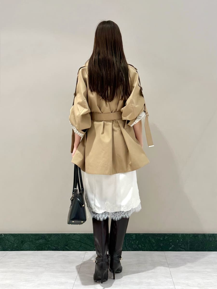 ベージュ系のトレンチコート、ホワイト系のスカート、ホワイト系のその他トップスを着用したレディースの秋コーディネートの3枚目の写真