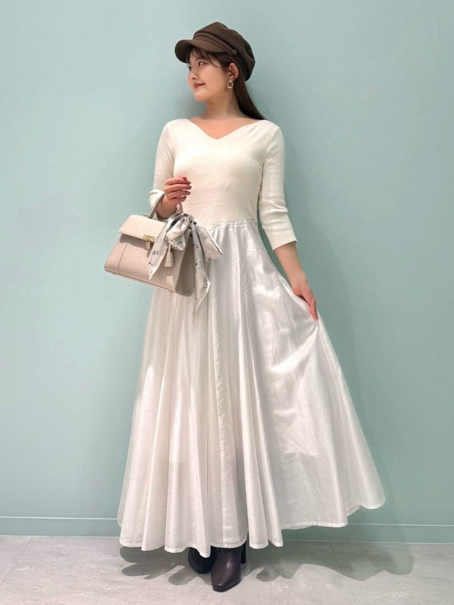 レッド系のブーツ、ベージュ系のトレンチコート、ベージュ系のハンドバッグを着用したレディースの冬コーディネートの3枚目の写真