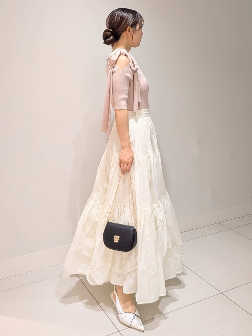 ホワイト系のスカート、その他のパンプス、ブラック系のショルダーバッグを着用したレディースの春コーディネートの2枚目の写真