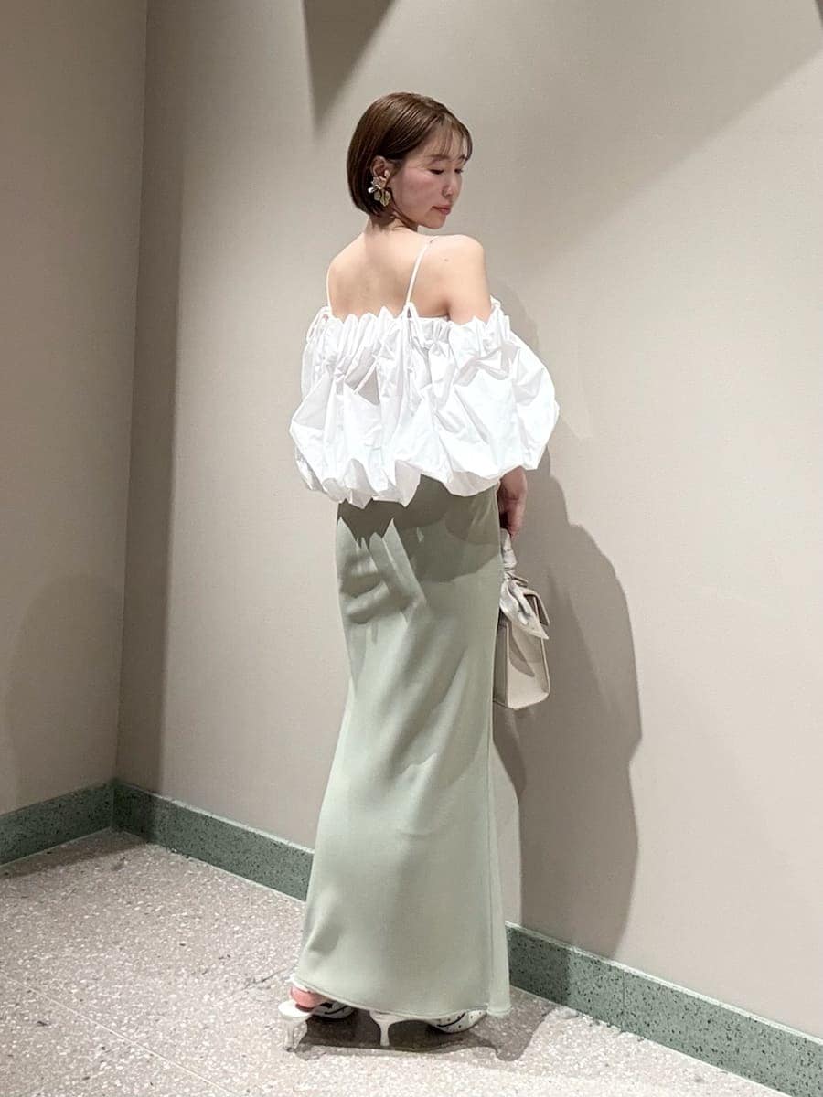 グリーン系のスカート、ホワイト系のシャツ/ブラウス、ホワイト系のハンドバッグを着用したレディースの春コーディネートの2枚目の写真